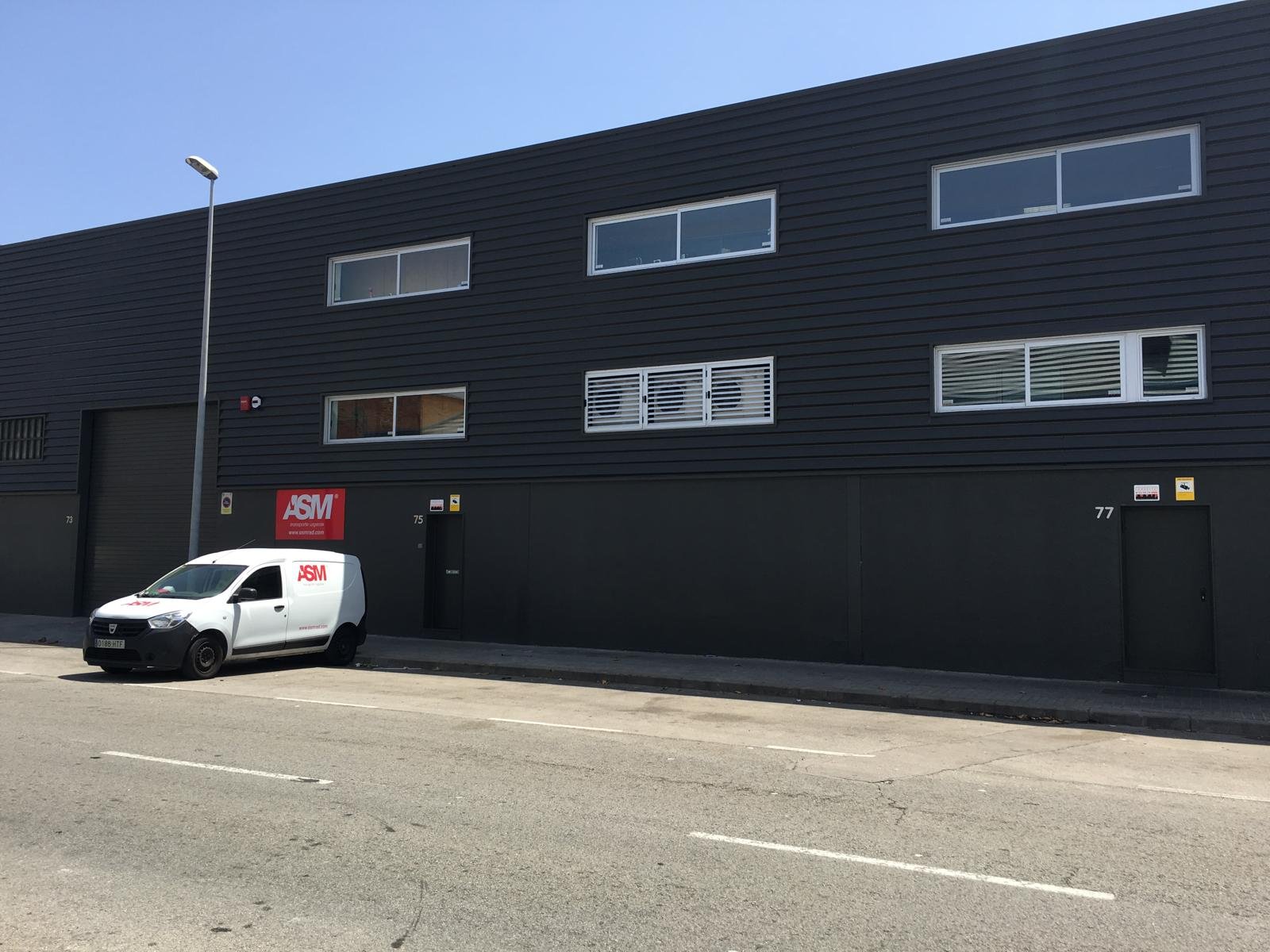 Fachada nave industrial con furgoneta saliendo